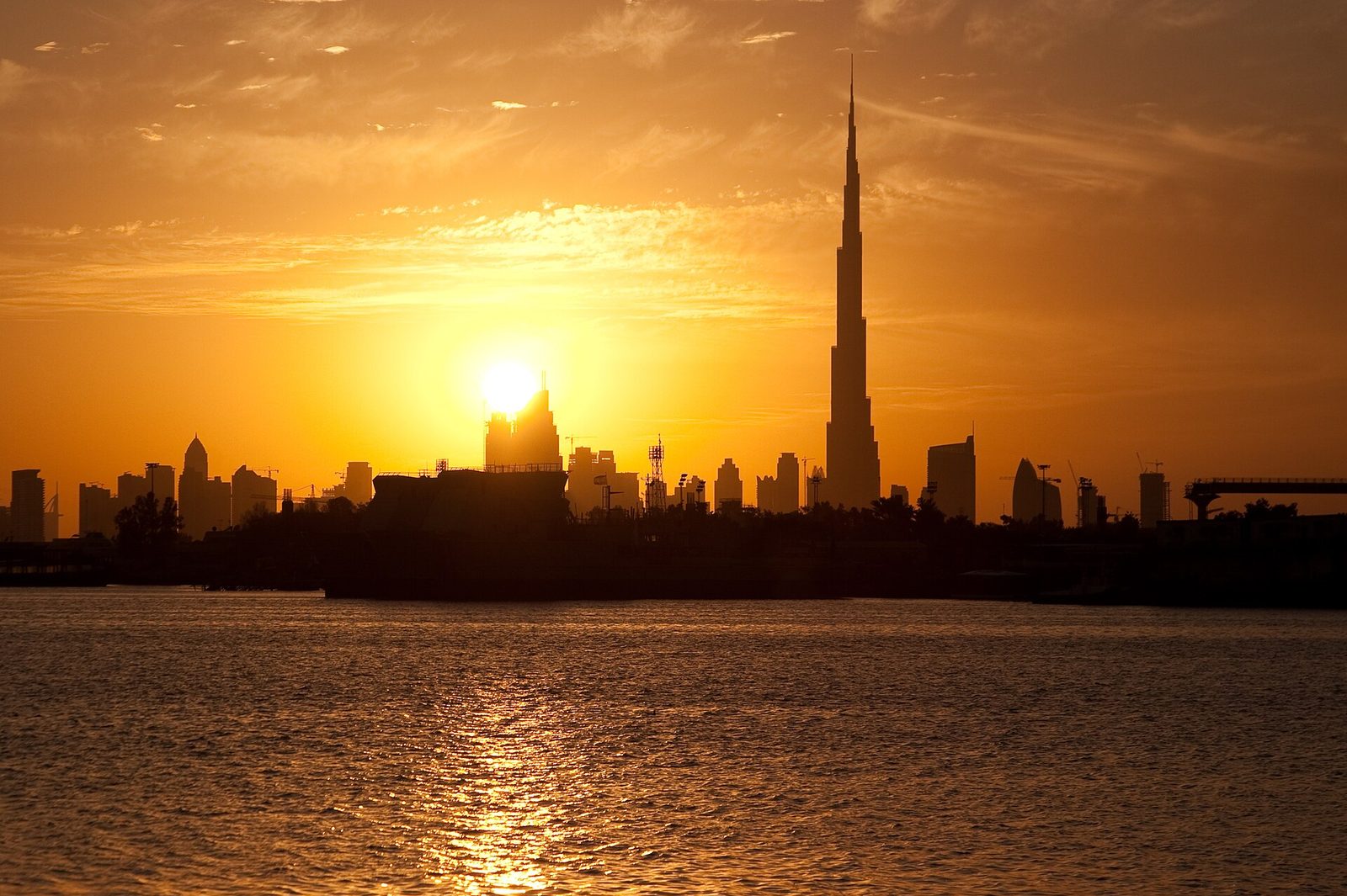 Dubai skyline and desert dunes at golden sunset
